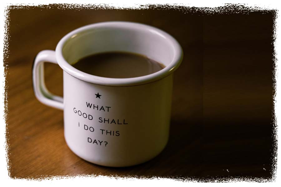 A coffee cup with What good shall I do this day? printed on it